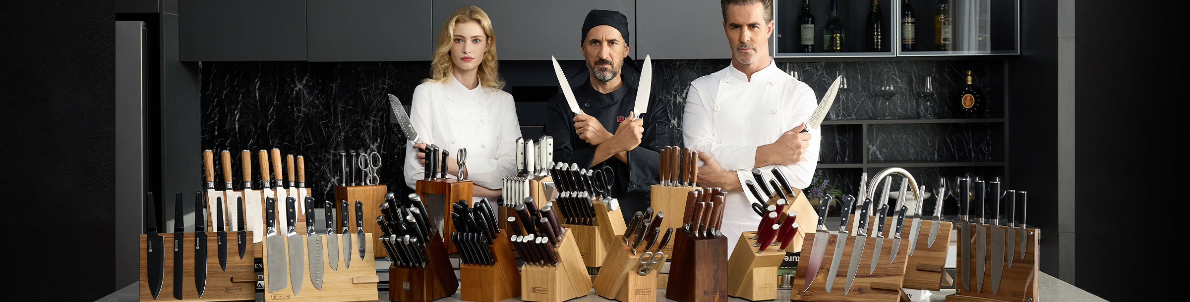 Team of chefs showcasing the full Paudin knife collection on a kitchen counter.1621243260e1af0c20-1